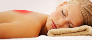 Stone massage therapy: Cute woman relaxing at a spa